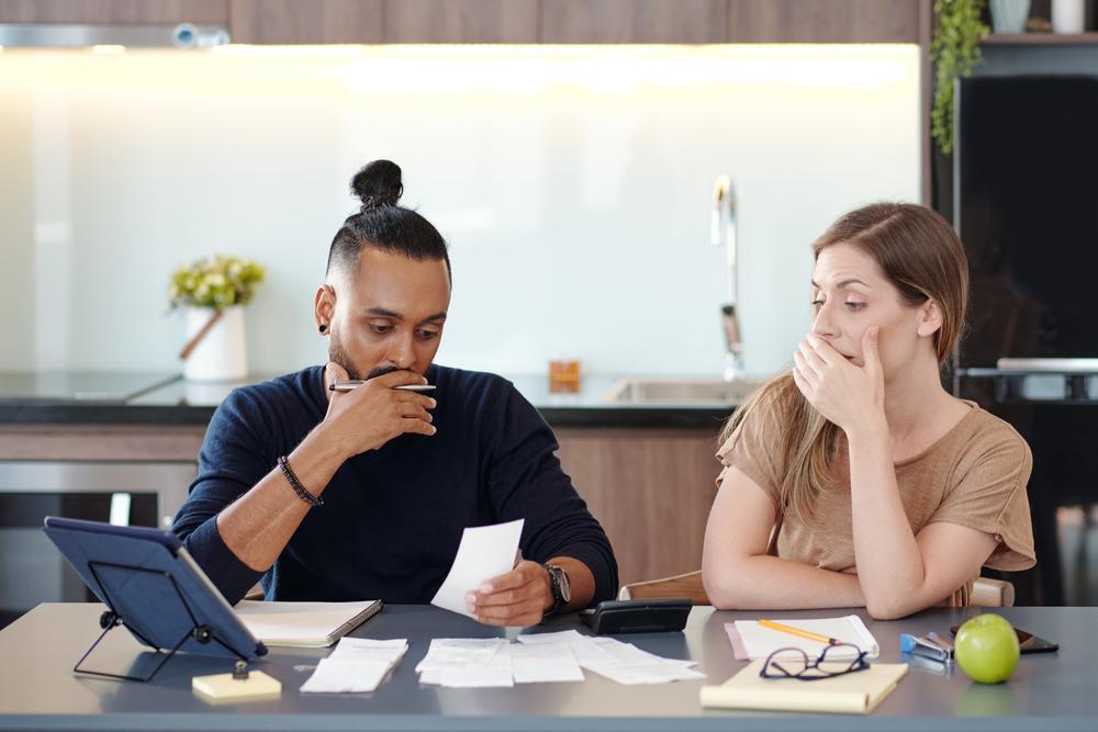 Dos personas sentadas en una mesa mirando una factura