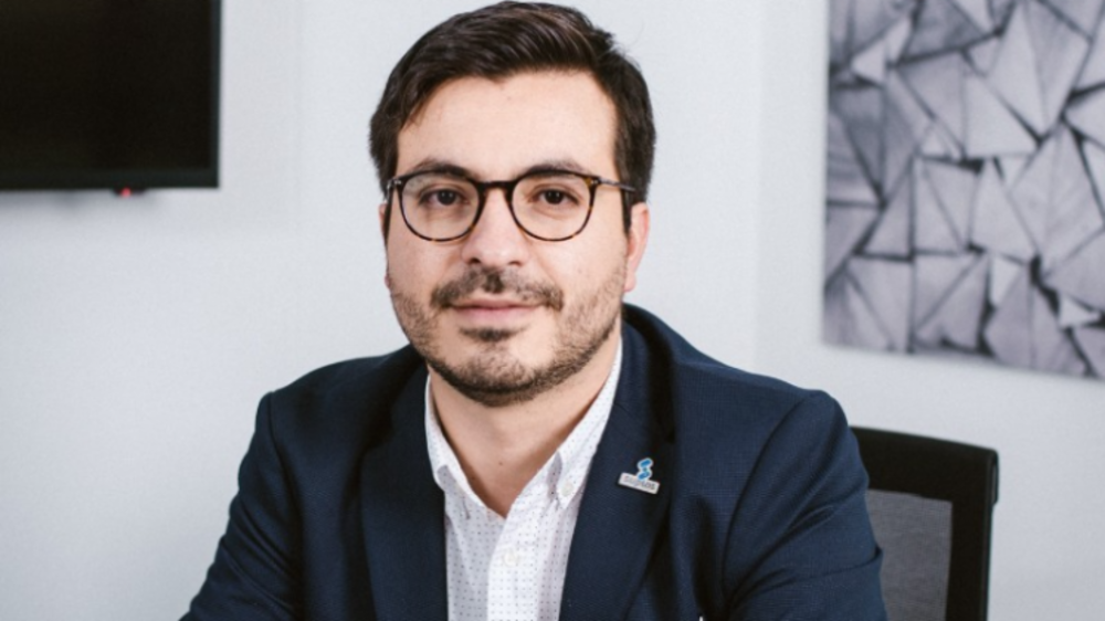 Okar Sarquis, foto de un hombre con traje y gafas mirando a la cámara