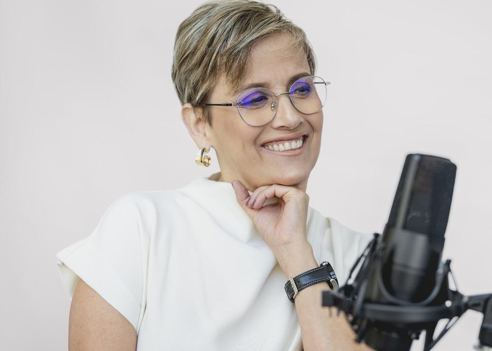 Foto de Patricia Velásquez, una mujer sonriente con un micrófono de frente