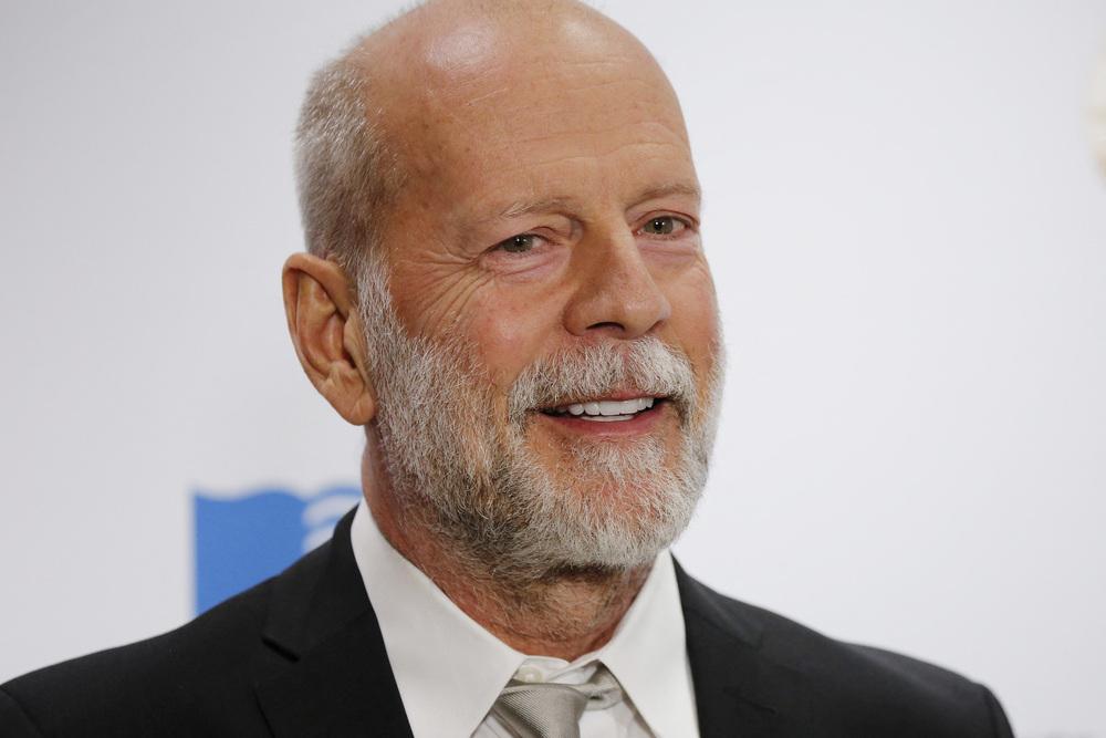 Foto de bruce willis, un señor con barba en traje y fondo blanco