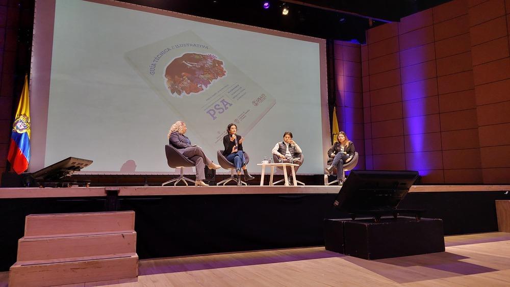 Foto de cuatro mujeres sentadas frente a un panel