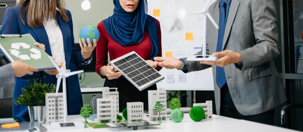 Foto de ejecutivos mirando un panel solar con un proyecto en la mesa