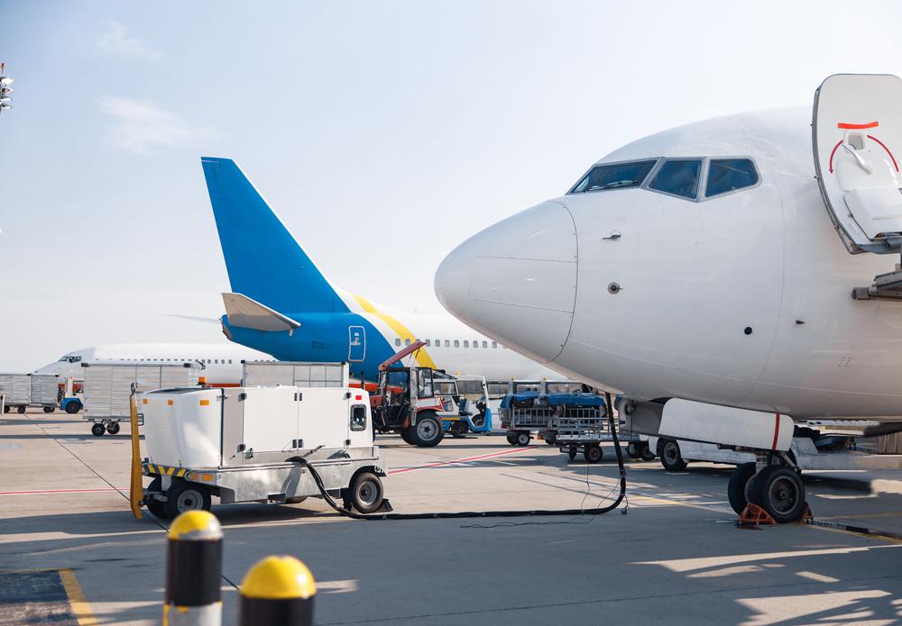 Foto de la parte delantera de un avión estacionado con otros de fondo