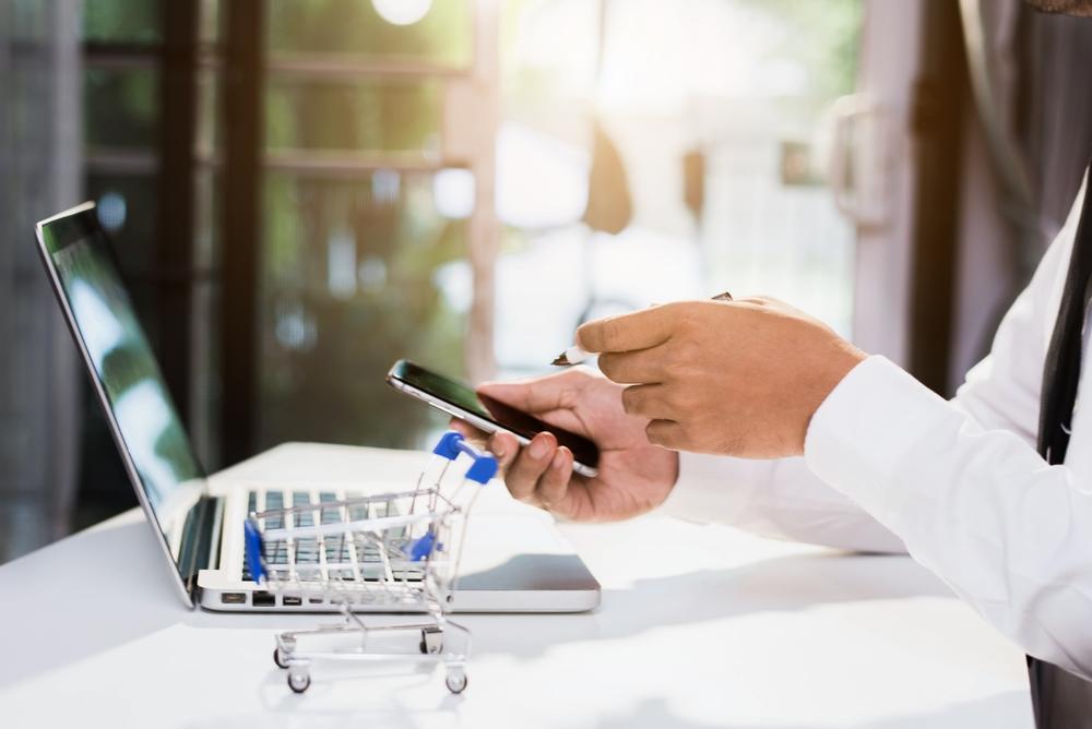 Foto de las manos de una persona comprando en línea por medio de un celular