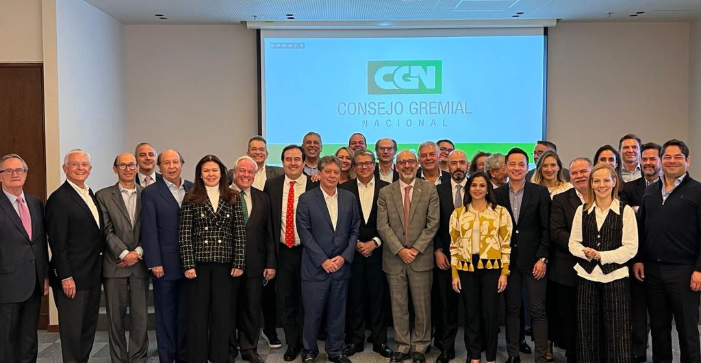 Foto de más de 10 personas con trajes mirando a la cámara