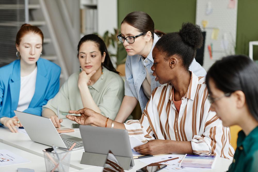 Foto de mujeres reunidas mirando un computador