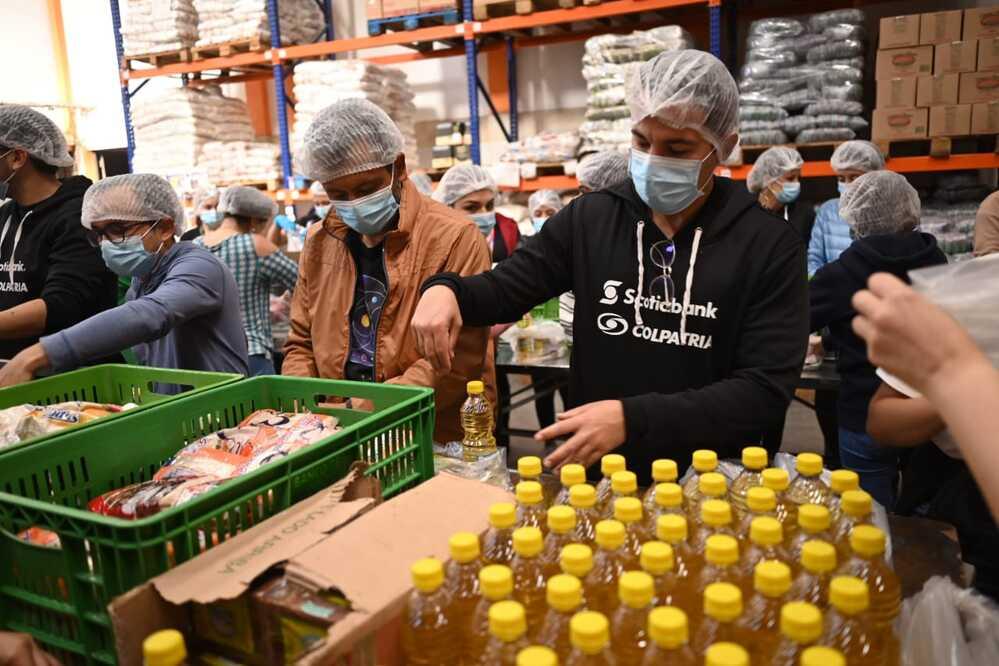 Foto de personas depositando productos en cajas