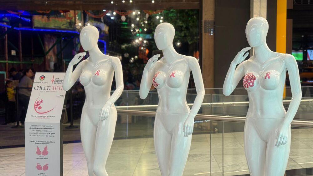 Foto de tres maniquies blancos con figuras rosadas