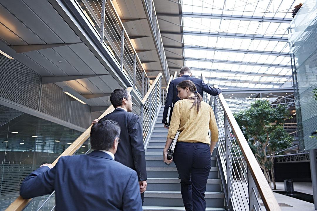 Foto de tres personas subiendo una escalera