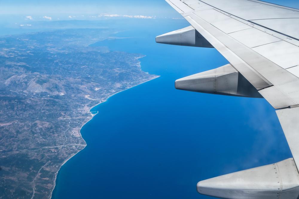 Foto de un ala de un avión y debajo la tierra y el mar