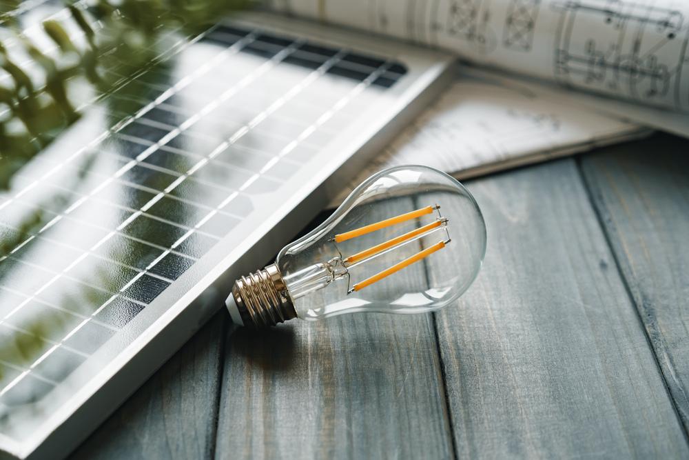 Foto de un bombillo con un panel de energía solar al lado