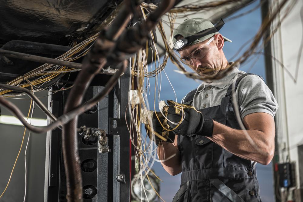 Foto de un electricista trabando con cables en sus manos