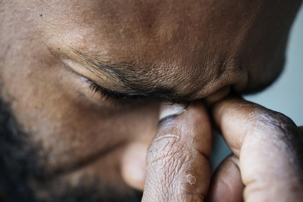 Foto de un hombre cogiendose los ojos, seña de que está estresado