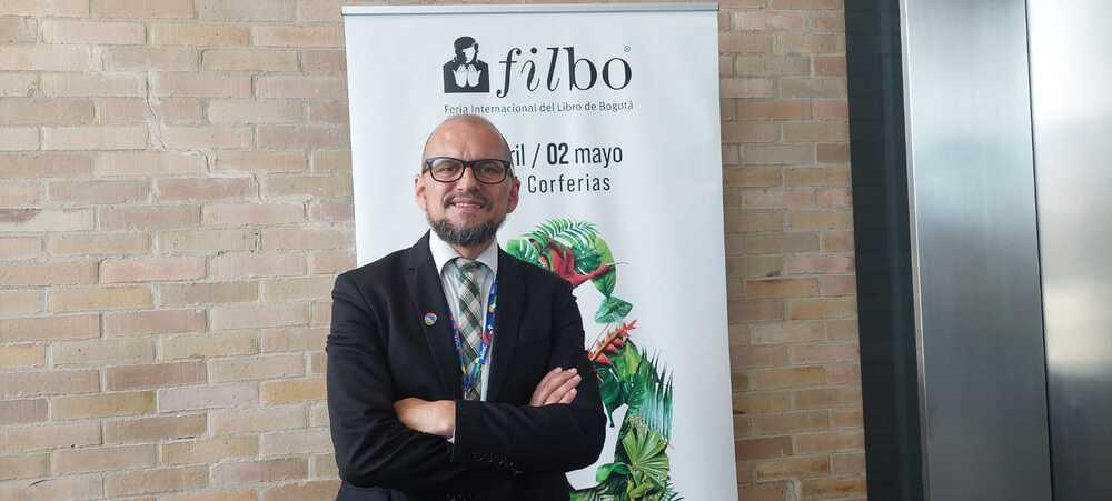 Foto de un hombre cruzado de brasil con barba y gafas negras mirando a la cámara