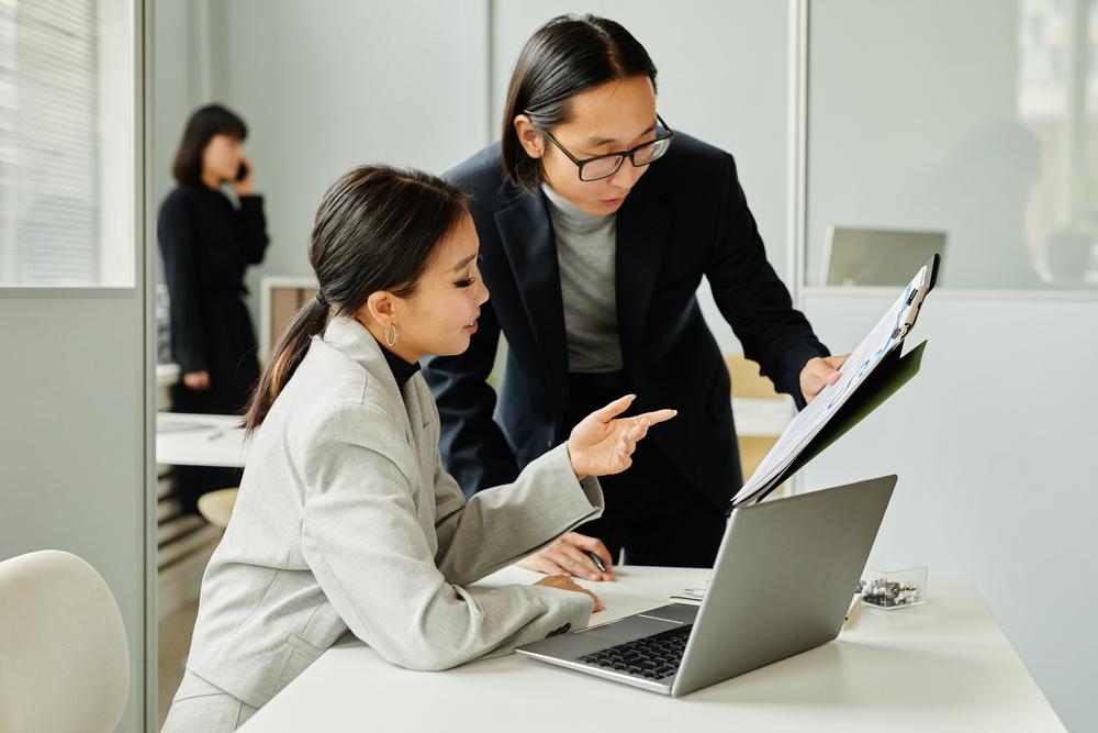 Foto de un hombre y una mujer trabajando frente a un computador