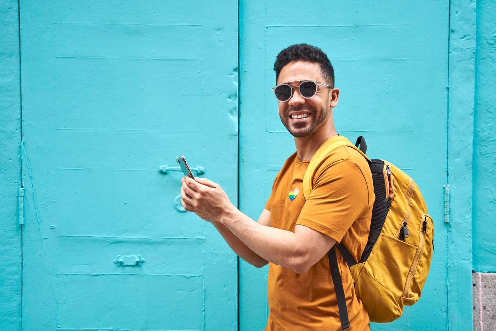 Foto de un joven sonriendo a la camara con camiseta amarilla