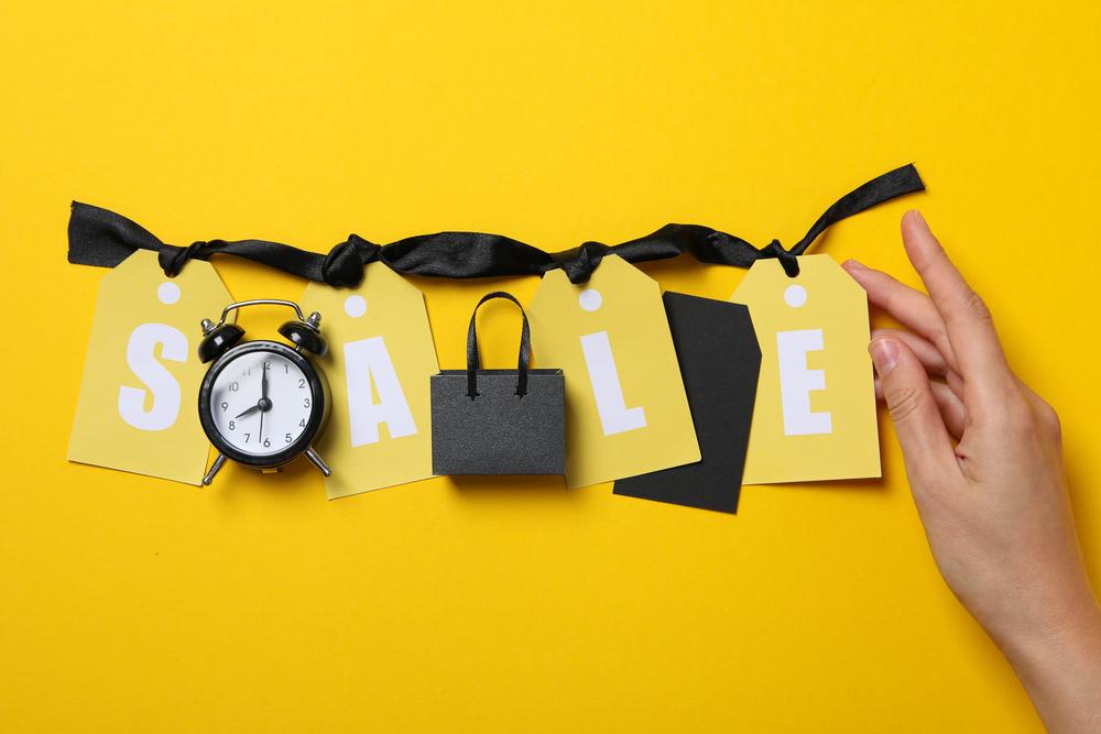 Foto de un letraro que dice sale con un reloj y un fondo amarillo