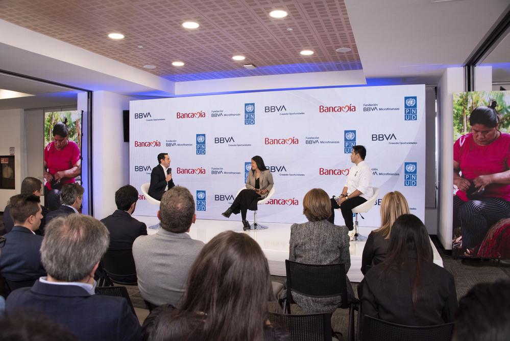 Foto de un panel con tres personas sentadas conversando Bancamía