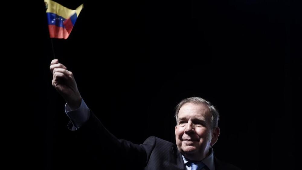 Foto de un señor con la bandera de venezuela en la mano derecha