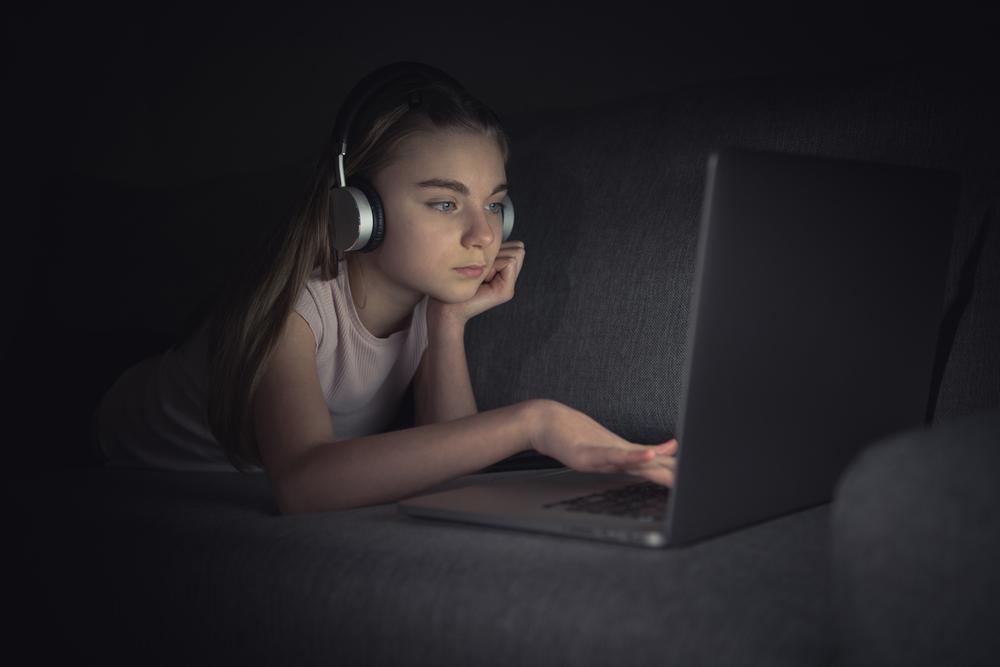 Foto de una chica mirando la computadora en la noche