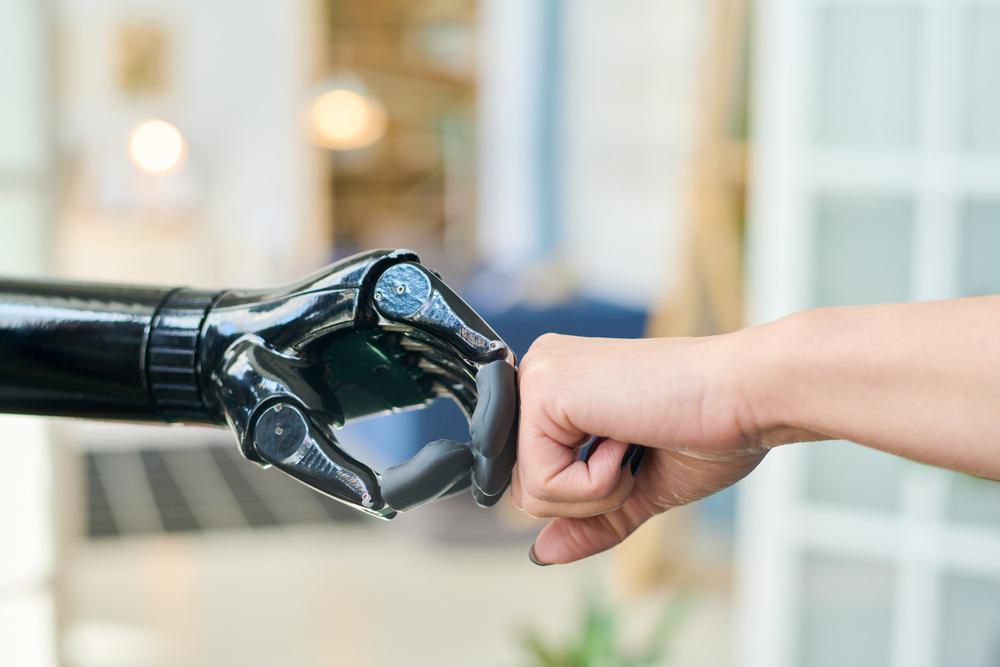 Foto de una mano natural y de un robot chocando