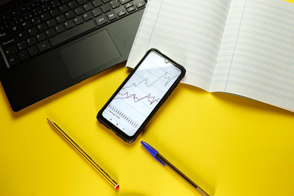 Foto de una mesa con un celular con una gráfica en su pantalla