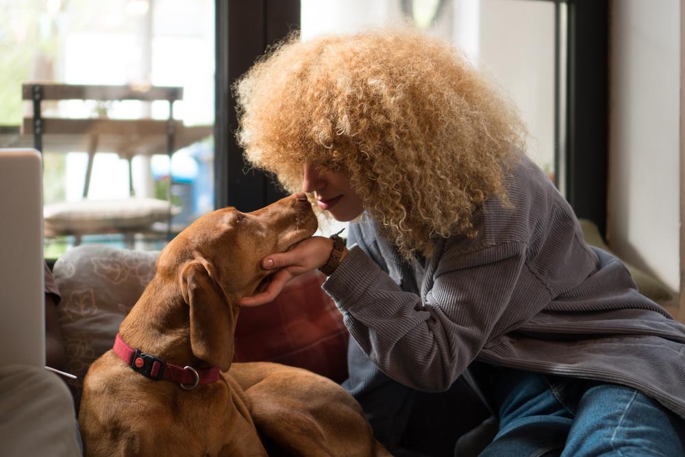 Foto de una mujer acariciando un perro