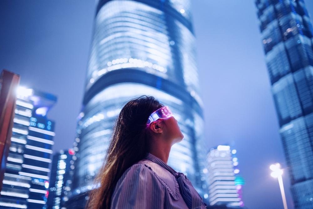 Foto de una mujer con gafas tecnológicas y un fondo de ciudad