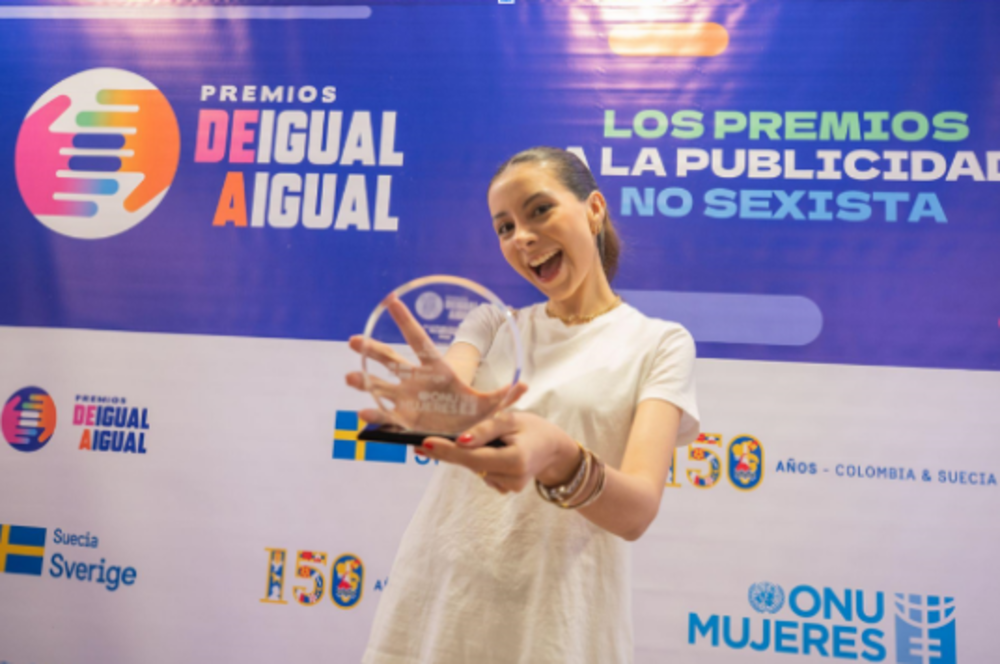 Foto de una mujer con un premio en sus manos 