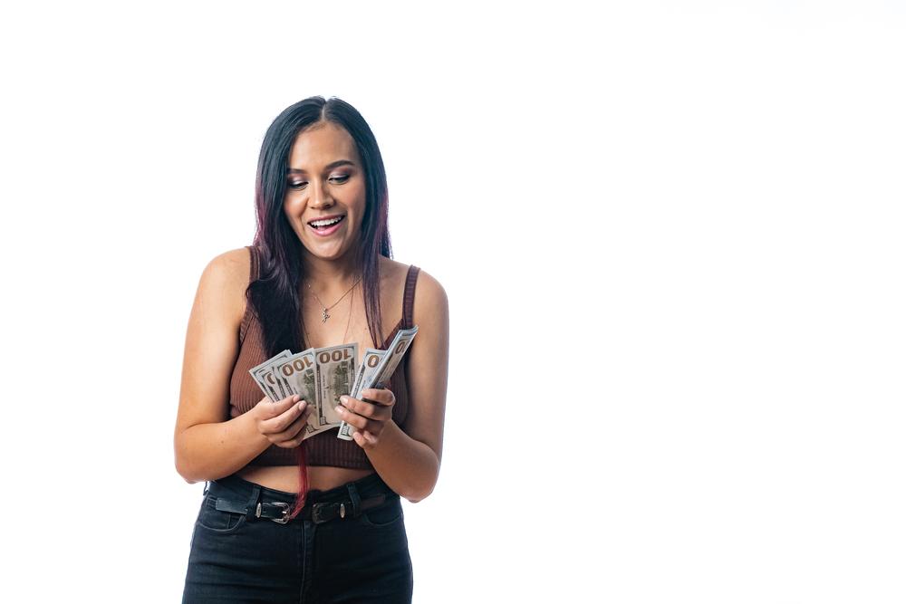 Foto de una mujer contando dinero con un fondo blanco