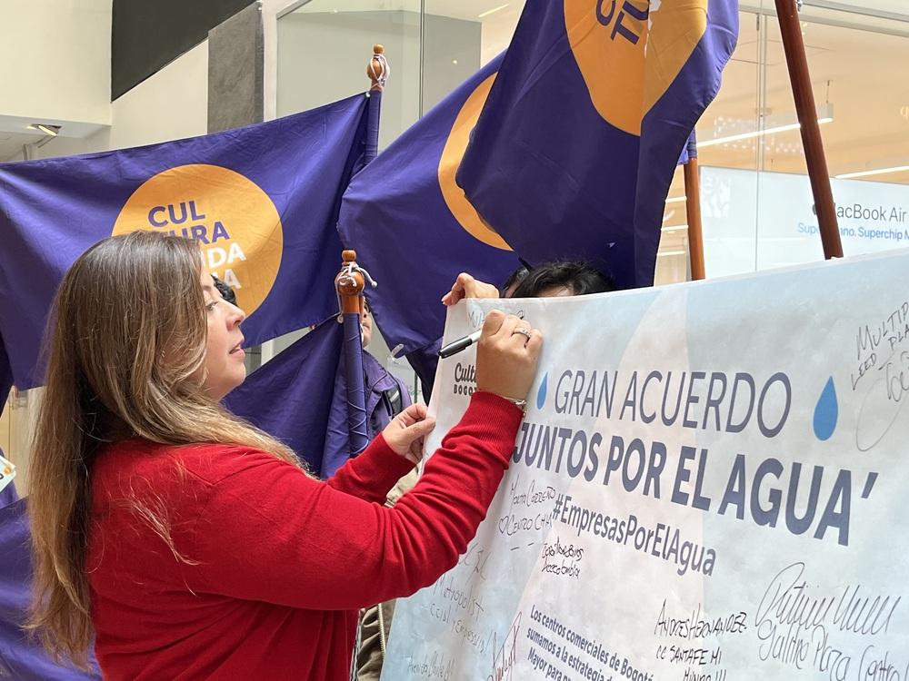 Foto de una mujer firmando un acuerdo con la mano