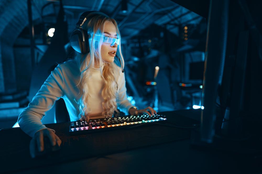 Foto de una mujer mirando un computador con unas gafas azules