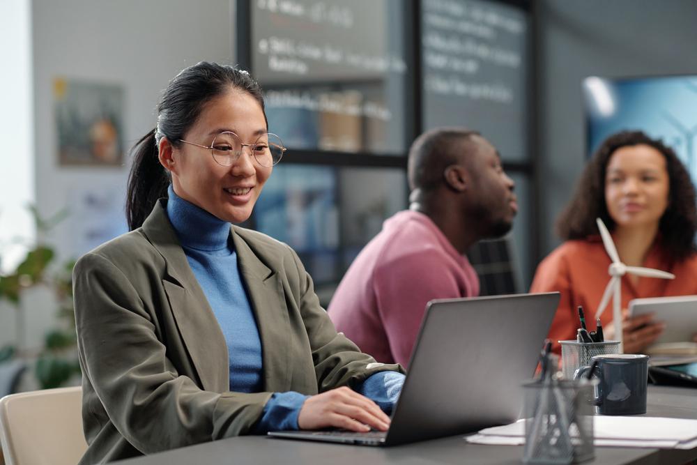 Foto de una mujer sonriendo frente a un computador