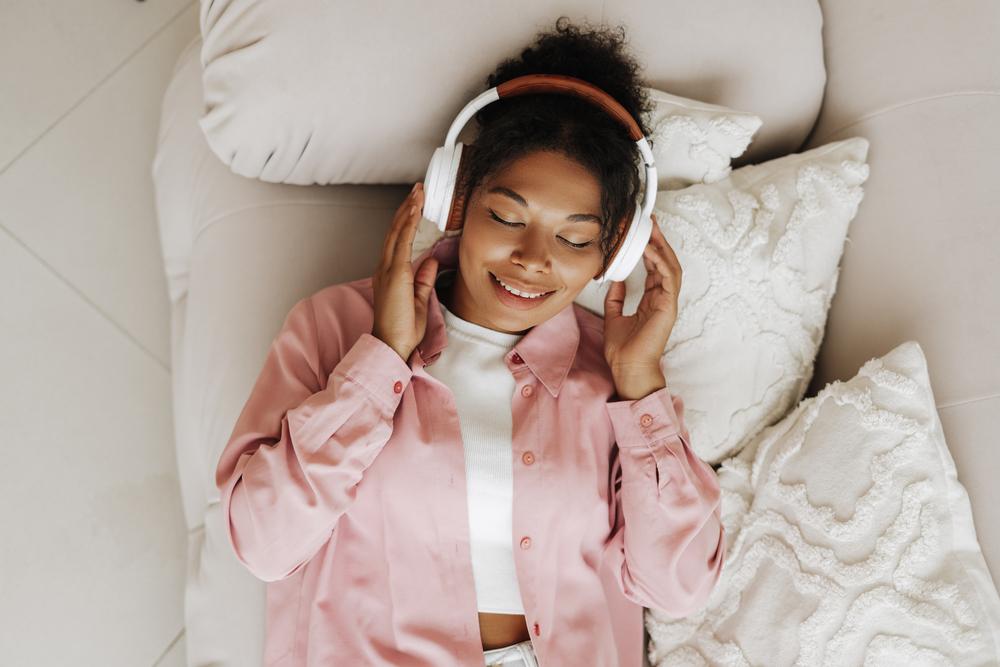 Foto de una mujer tocandose los oidos mientras escucha música