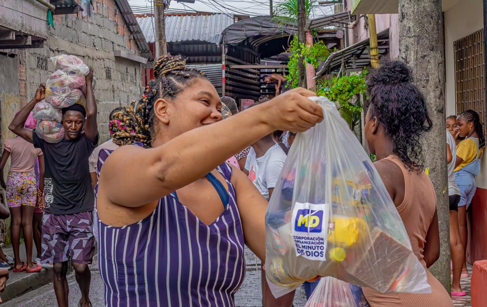 Foto de una mujer tomando una bolsa con productos