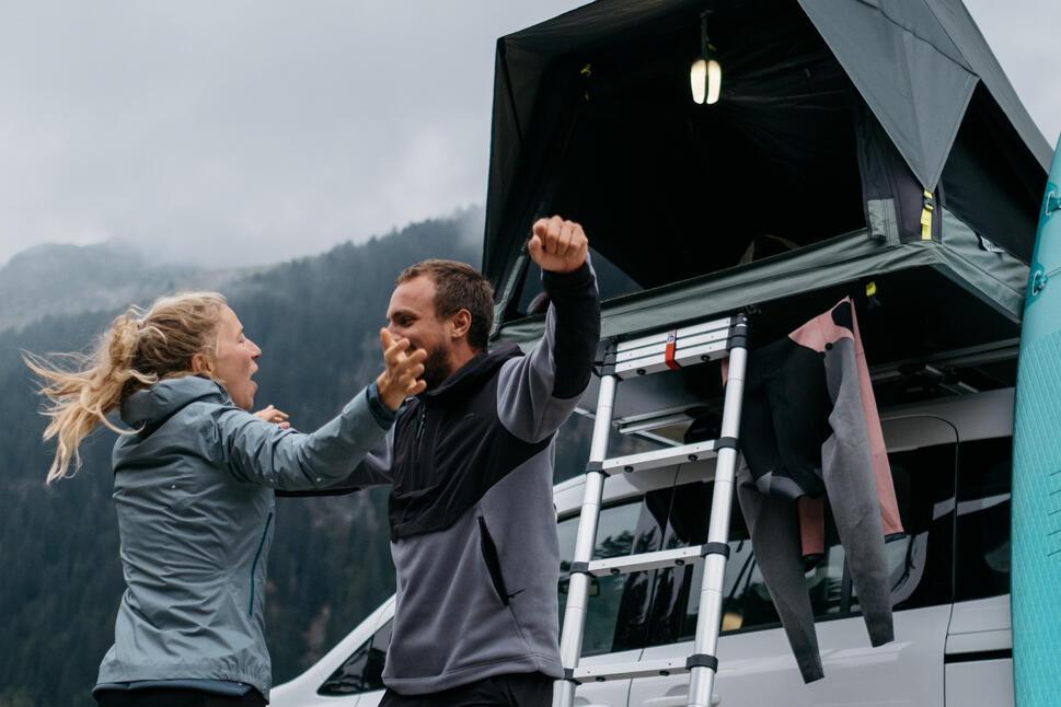 Foto de una pareja acampando con una carpa plegable de fondo