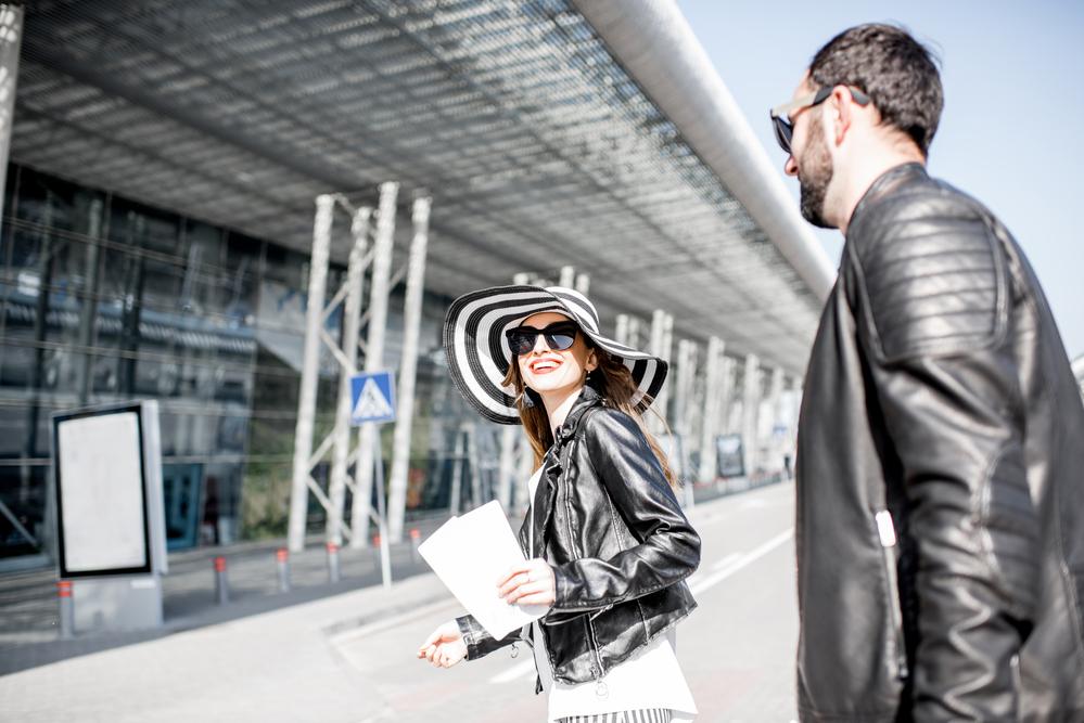 Foto de una pareja con chaqueta negra entrando a un aeropuerto