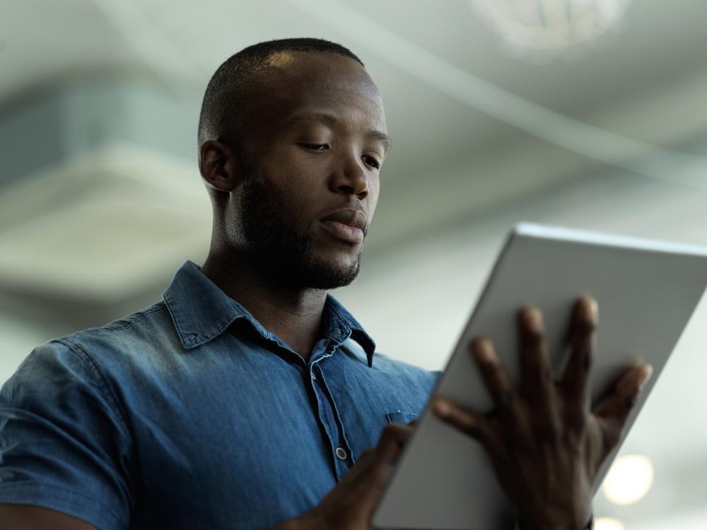 Foto de una persona afro con una tablet en la mano