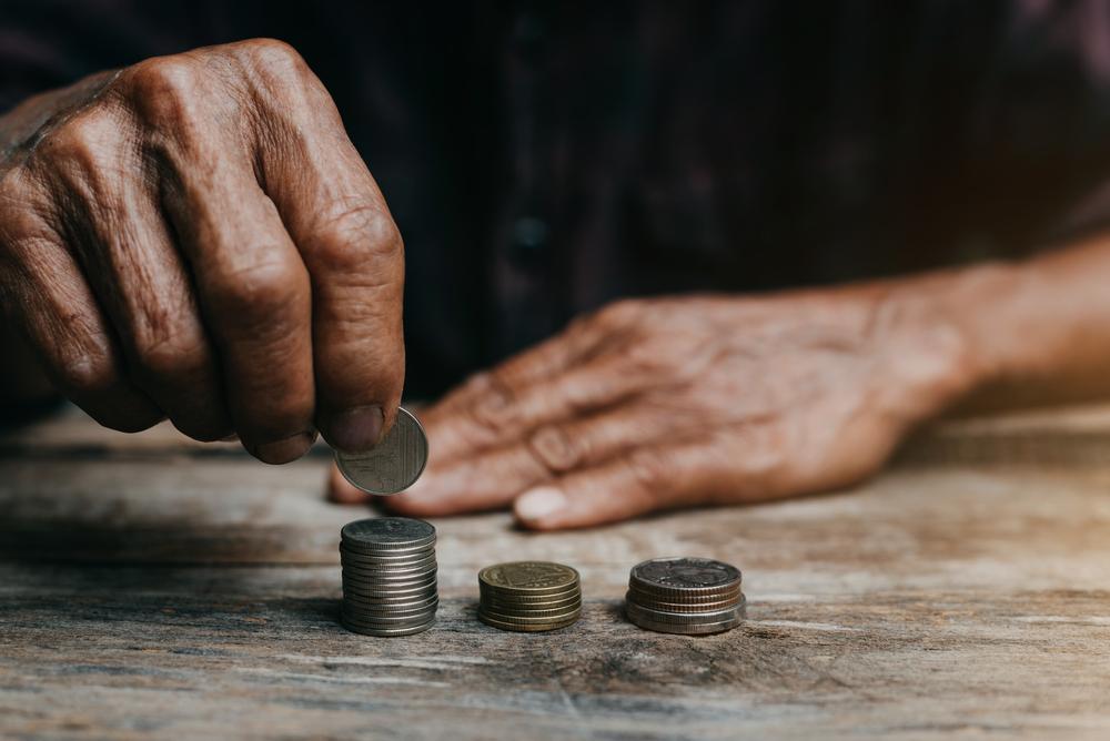 Foto de una persona apilando monedas sobre una mesa