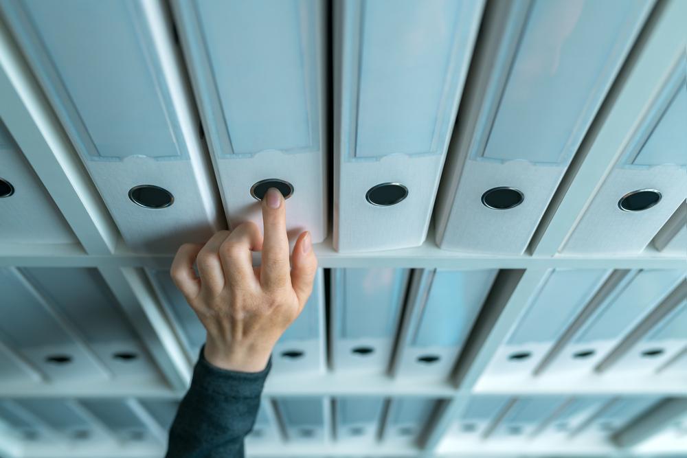 Foto de una persona buscando unos folders en una carpeta de negocios