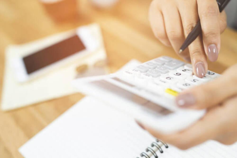 Foto de una persona con una calculadora en la mano