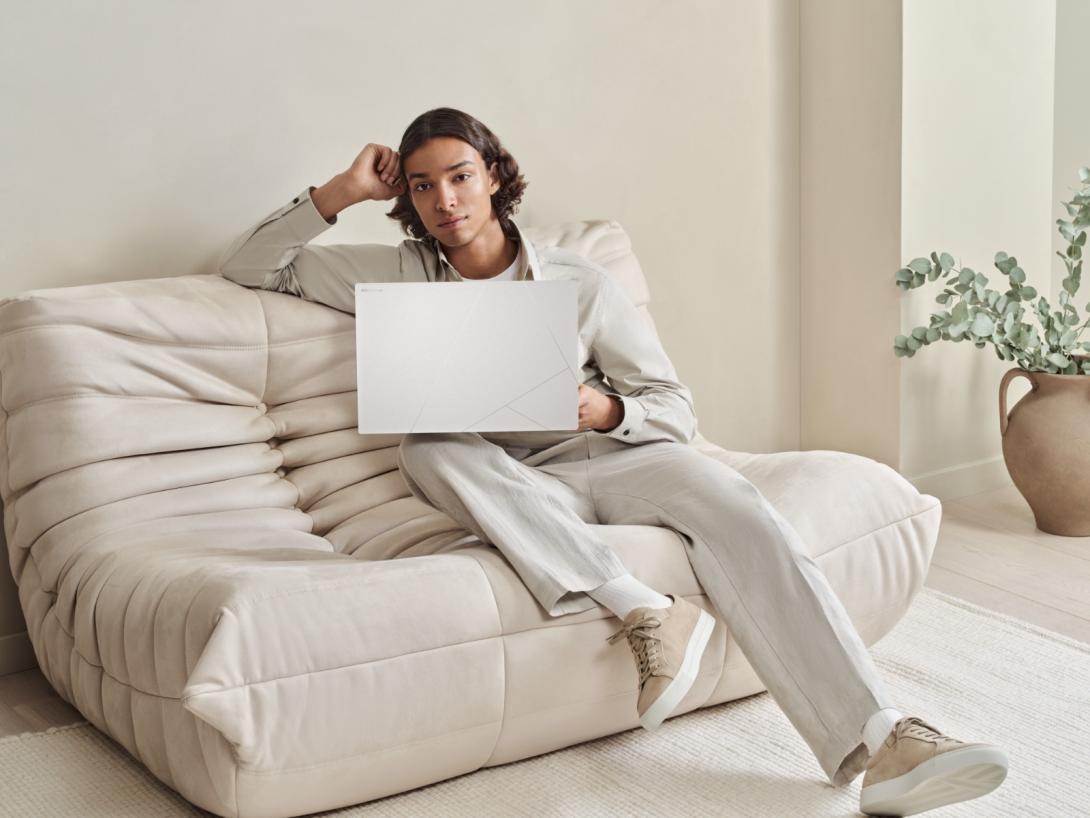 Foto de una persona con una computadora asus blanca sobre un sofa