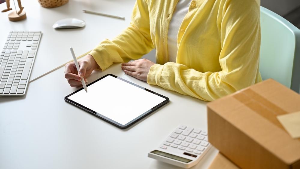 Foto de una persona con una tablet en la mesa