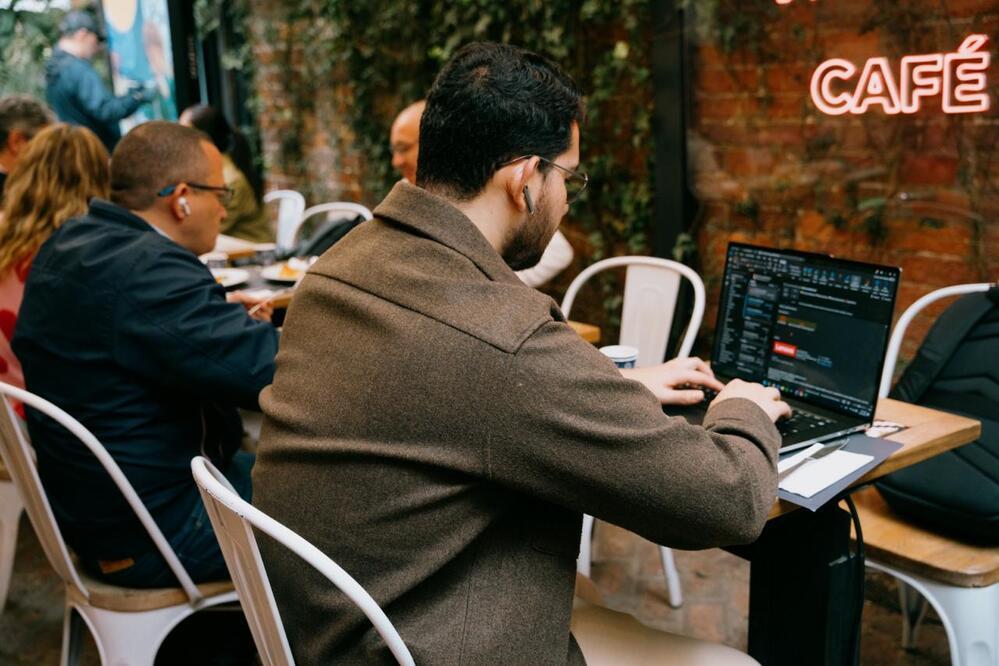 Foto de una persona de espaldas escribiendo sobre un computador