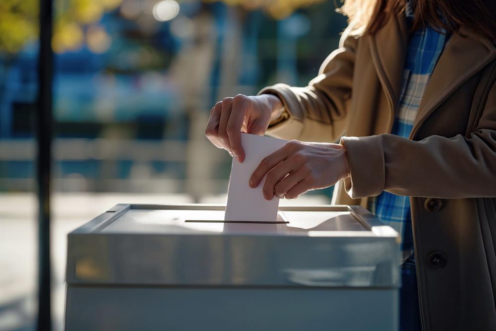 Foto de una persona depositando una hoja en una caja