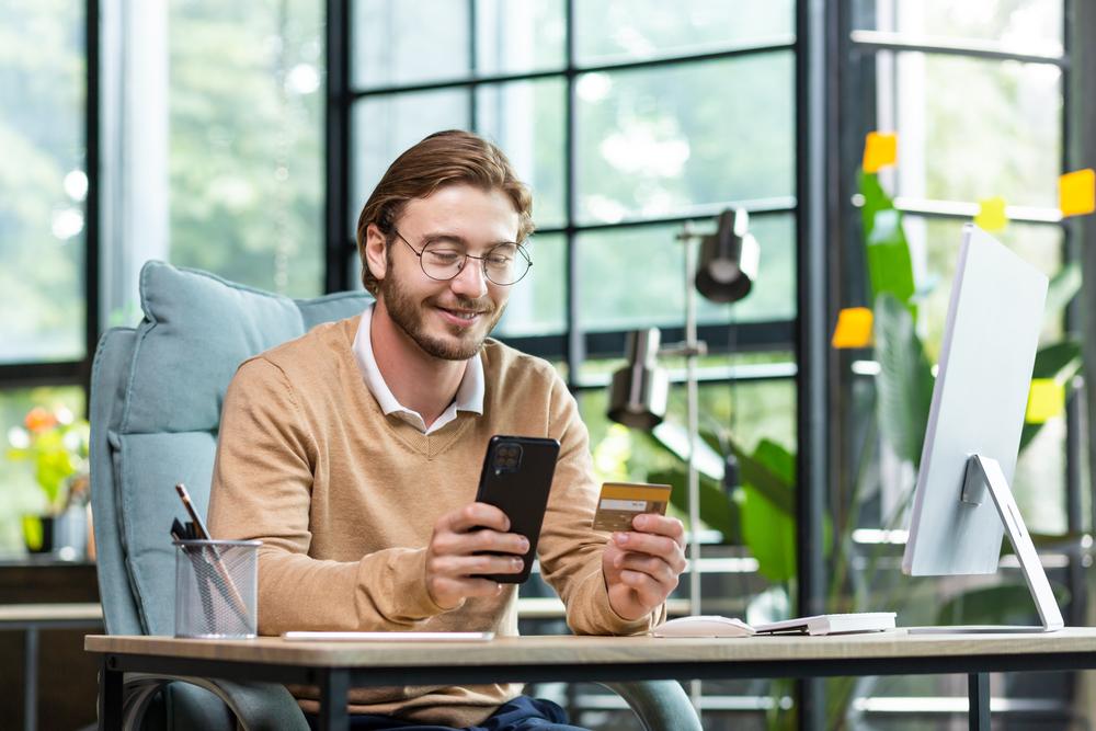 Foto de una persona mirando un celular con un fondo empresarial