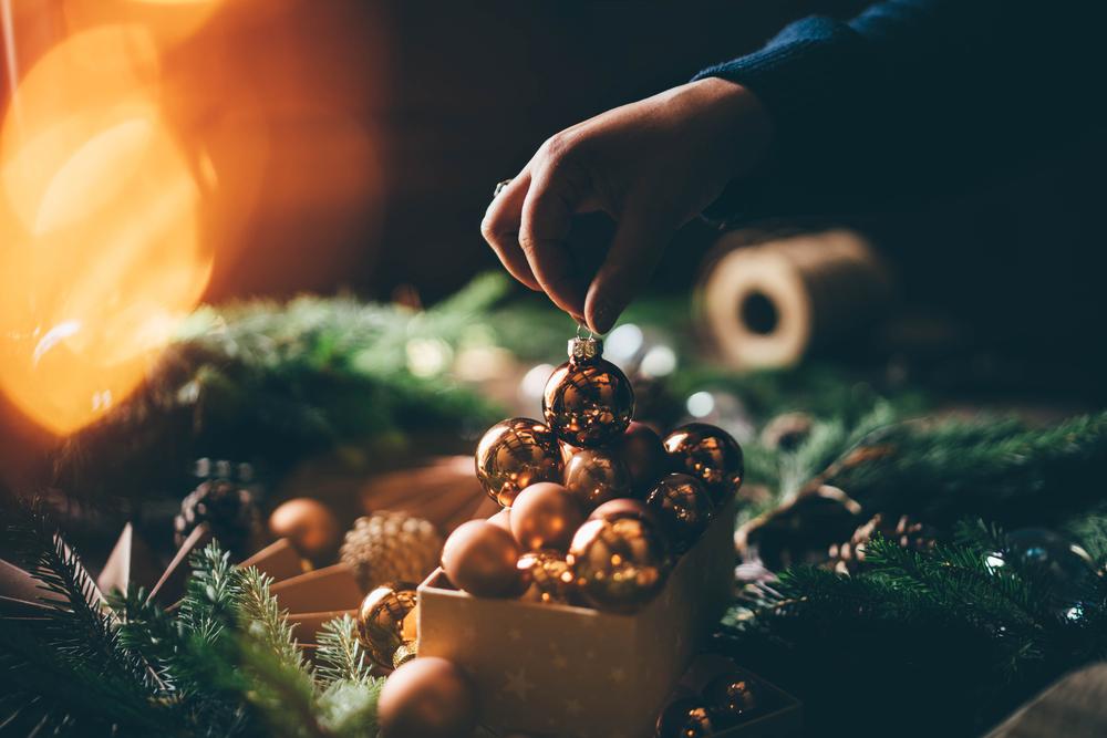 Foto de una persona poniendo bolas de navidad en un recipiente