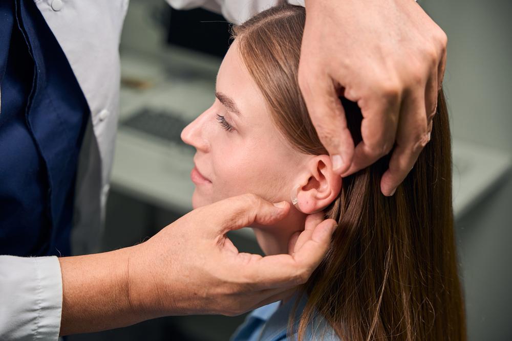 Foto de una persona revisando la oreja de una mujer