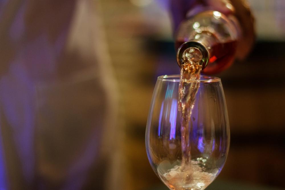 Foto de una persona sirviendo una copa de vino