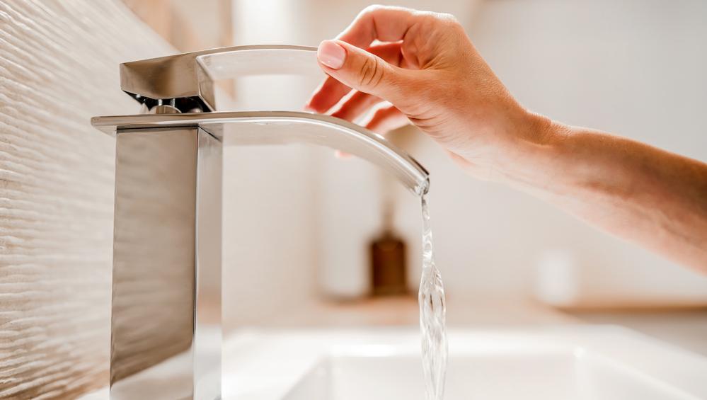 Foto de una persona utilizando un grifo de agua